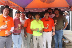 Rodeo Day winners hold their trophies after winning Rodeo Day at Trident Construction's May Superintendents Meeting